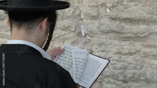 close up of a jewish man worshiping with a prayer book at the western wall in jerusalem, israel photo