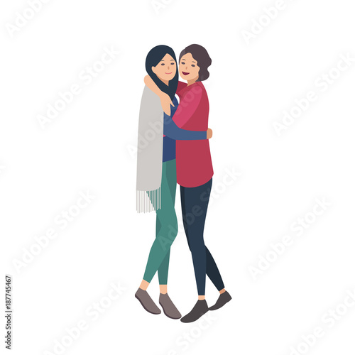 Pair of pretty young women standing together and hugging