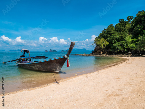 Long thail boat on the beach of an empty island Koh Nok in Thailand.