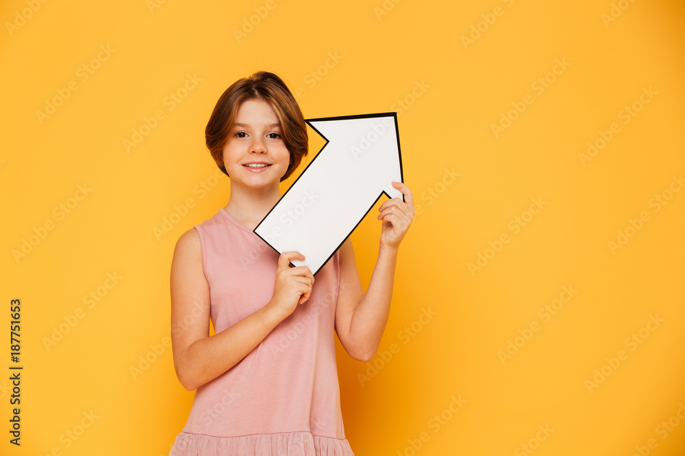 Fototapeta premium Cheerful handsome girl holding arrow left and looking camera