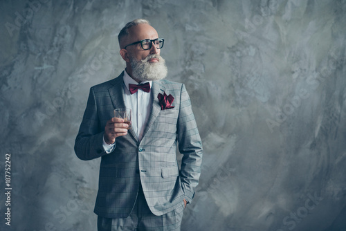 Well-off luxurious lifestyle. Portrait of confident respectable planning handsome brutal masculine sharp-dressed checkered grey tux vinous handkerchief drinking beverage isolated on background