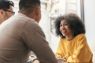 Group of happy friends chatting in the coffee shop.