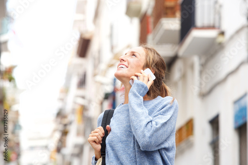 Smiling woman in the city talking on cellphone