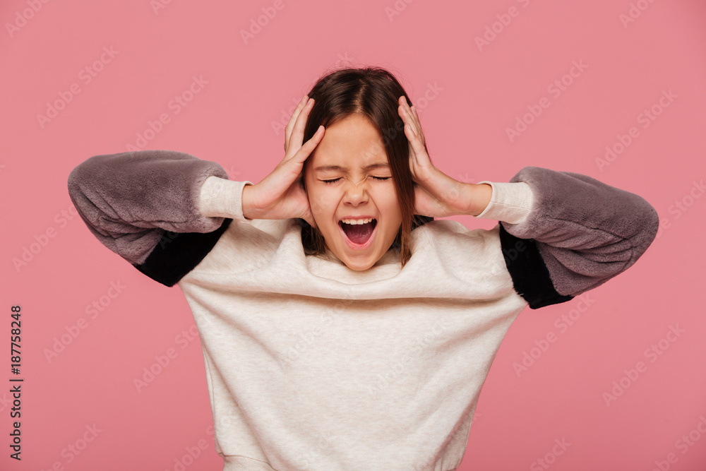 Angry girl screaming and holding head with hands isolated Angry girl screaming and holding head with hands isolated
