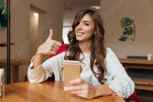 Portrait of a joyful woman holding mobile phone