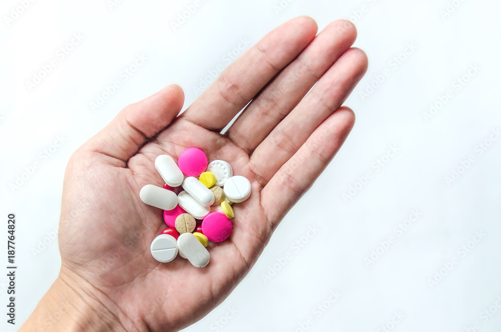 Top view of the pills on the hand and white background, A hand hold the pills and drug, Pile of the drug and pills on the hand. Top view of the pills on the hand and white background, A hand hold the pills and drug, Pile of the drug and pills on the hand.