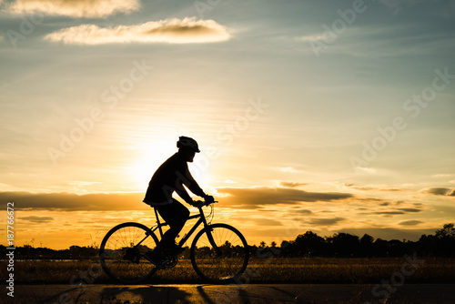 Fototapeta Naklejka Na Ścianę i Meble -  Silhouette man cycling at sunset