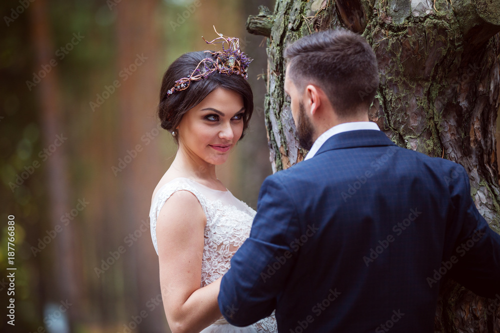 bride looks playfully at groom near tree bride looks playfully at groom near tree