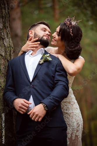 bride smiles and hugs groom from back