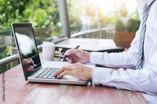 Image of businessman working with laptop, tablet and financial document data graph on table in outdoor office, finance,investment, business concept