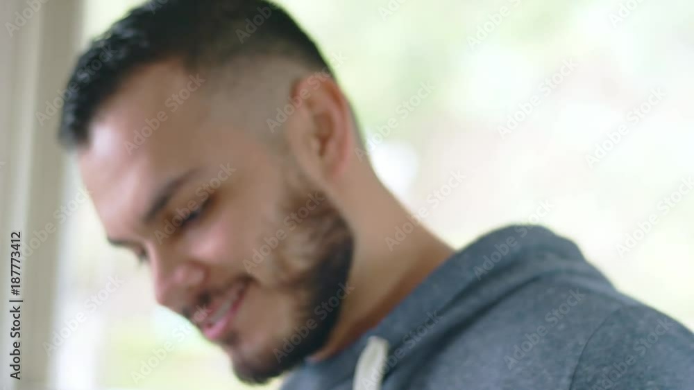 Young handsome hispanic man watches water boil in tea kettle Young handsome hispanic man watches water boil in tea kettle
