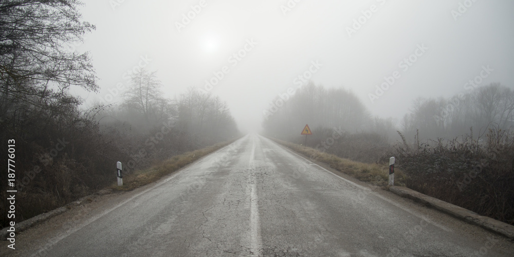 Fototapeta premium Droga asfaltowa z mgłą zimą