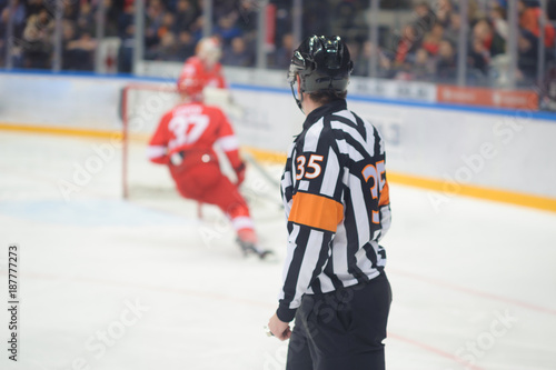 Hockey referee rides on ice, gates, players