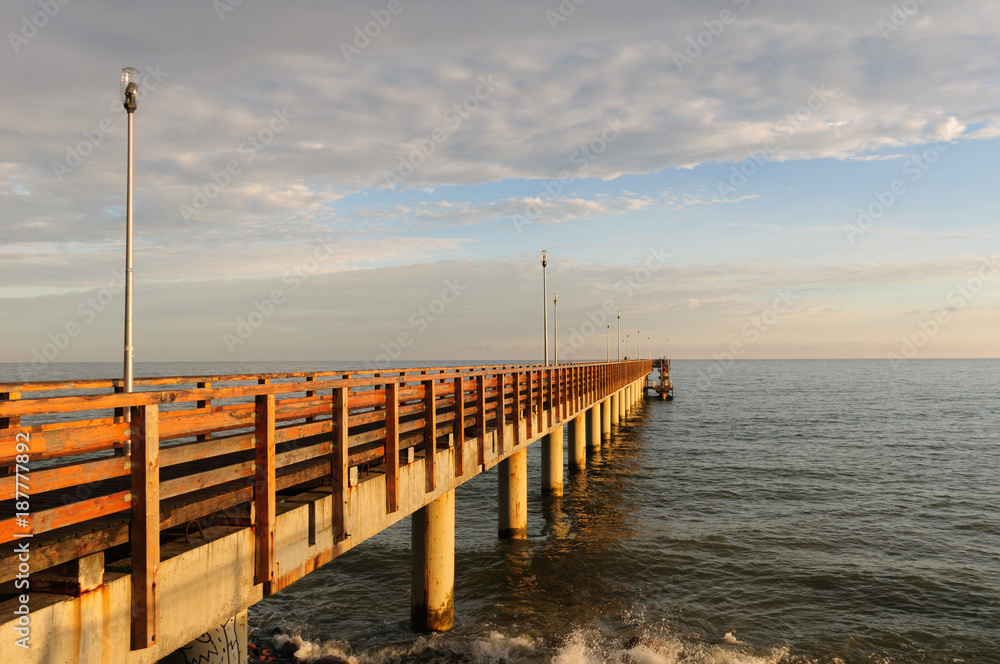Naklejka premium Pier on the beach, sunset