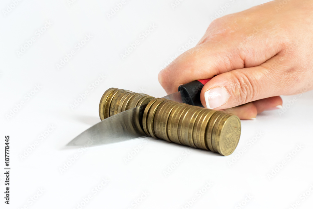 Knife cutting a pile of coin.