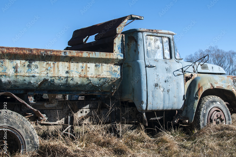 Old abandoned dirty broken vintage truck in the middle of paintball field playground