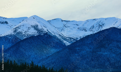 Mountain snow peak  beautiful natural winter backdrop. Ice top of the hill  blue sky background. Alpine landscape.