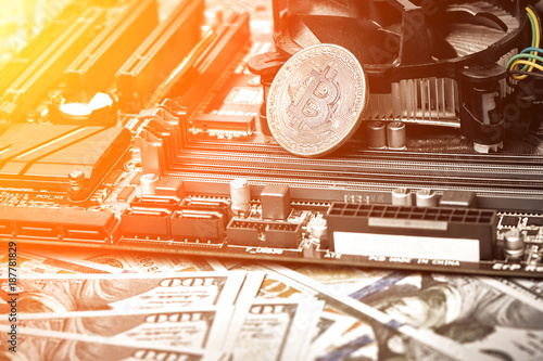 The coin of bitcoin lies on video card with dollars. Exchange bitcoin cash for a dollar. Sun flare photo