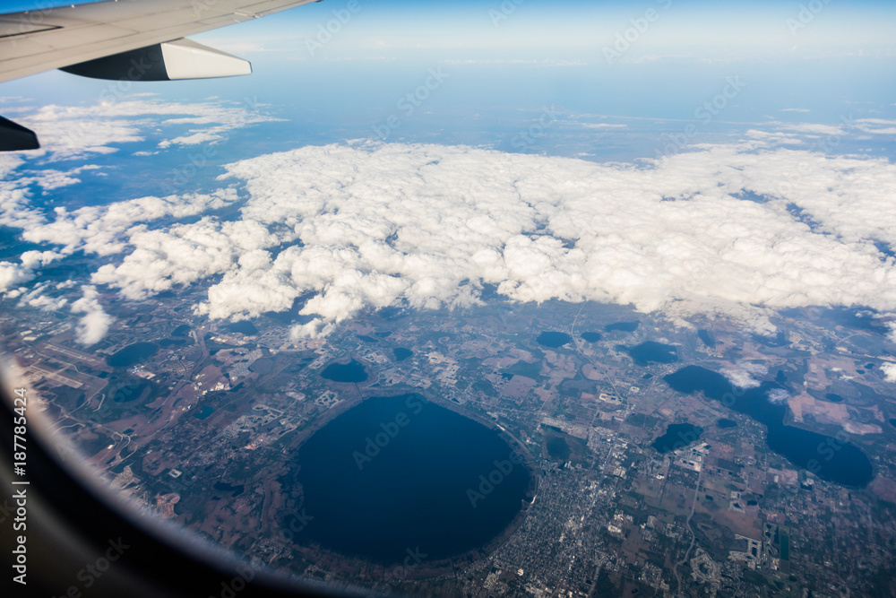 Jet wing and white cloudscape in blue sky from window Jet wing and white cloudscape in blue sky from window