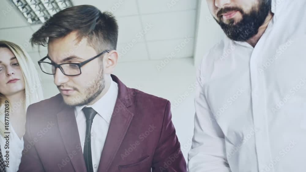 Young team of coworkers making great work discussion in coworking office. Bearded man talking with colleagues about new startup project. Young team of coworkers making great work discussion in coworking office. Bearded man talking with colleagues about new startup project.