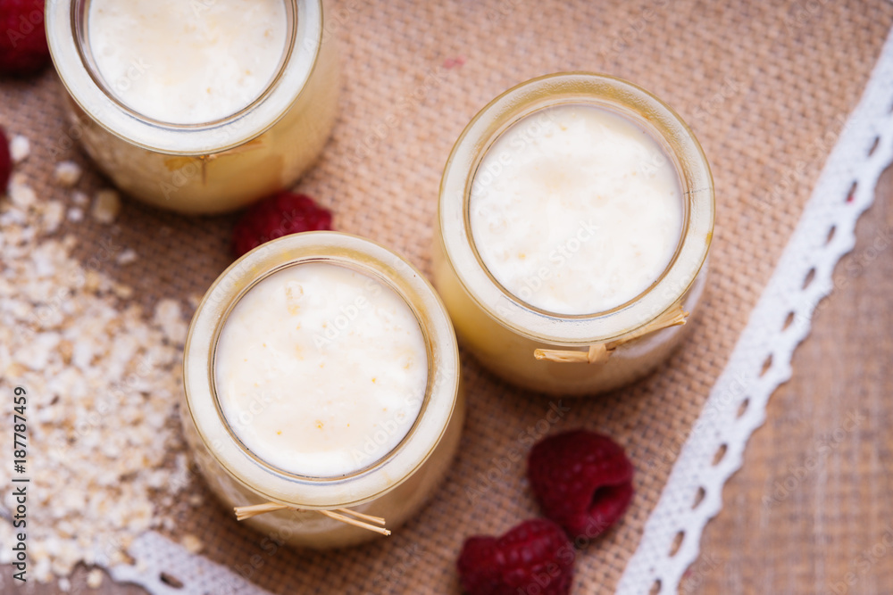 Jars with yogurt, raspberries and oat flakes Jars with yogurt, raspberries and oat flakes