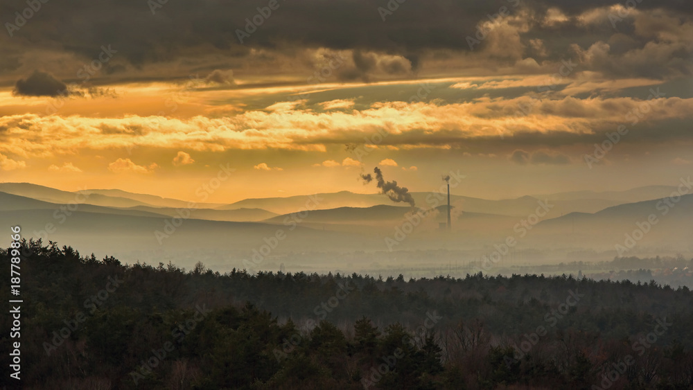 Fototapeta premium Smog hell - sunset. View from afar the city and a factory chimney with lots of smoke and smog. Europe, landscape Slovakia, Novaky. Chemical factory. Abstract. Global warming of the earth.