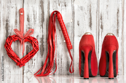 red shoes lash heart handcuffs on a wooden background
