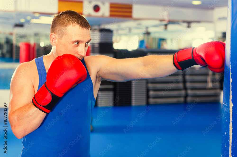 Potrait of man boxer who is training in gym.