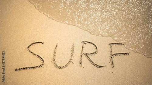 Surf word is written on the beach sand © anastasiapelikh