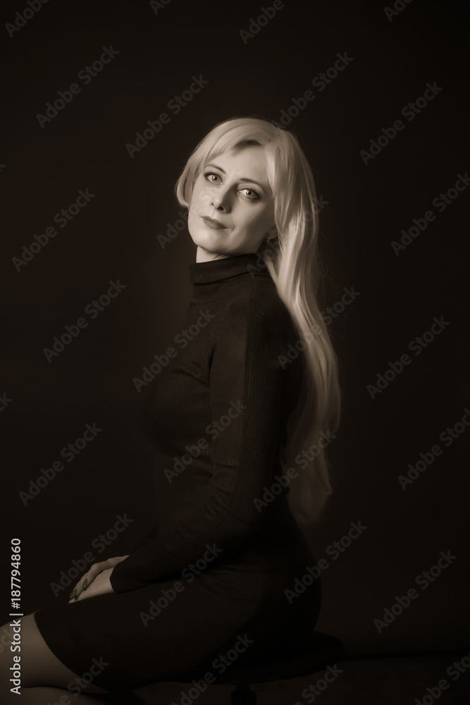Photo shooting indoors. On a black background. A woman with long white hair, wearing a black jacket.
