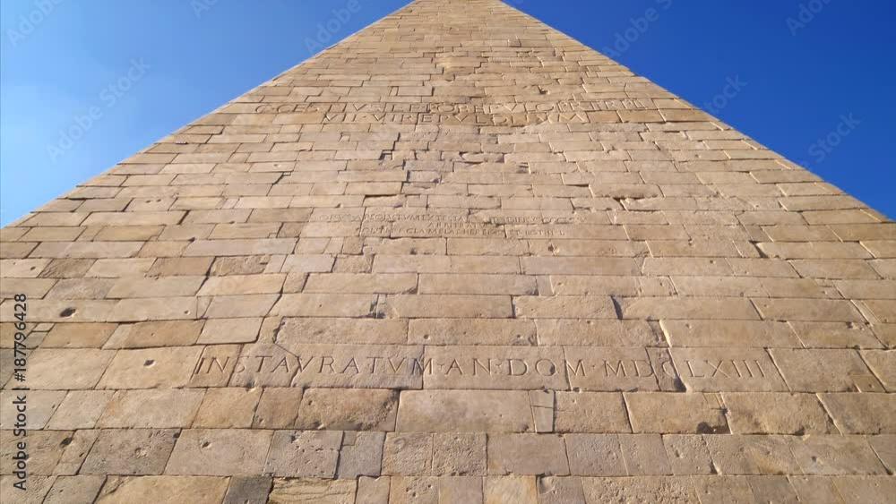Ancient Roman Pyramid of Cestius against blue sky in Rome, Italy Ancient Roman Pyramid of Cestius against blue sky in Rome, Italy