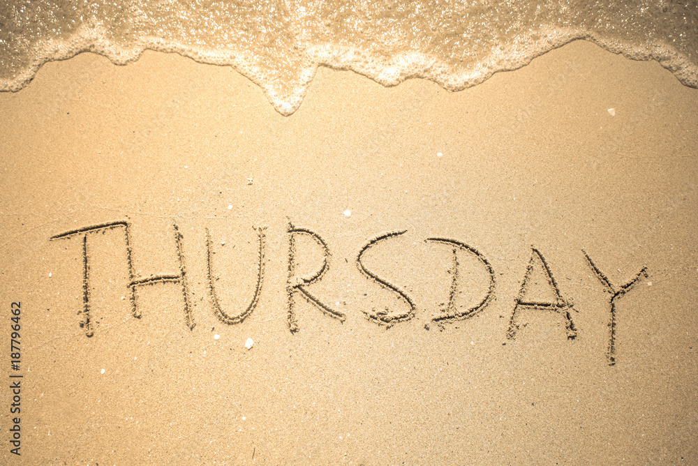 Fototapeta premium Thursday word is written on the beach sand