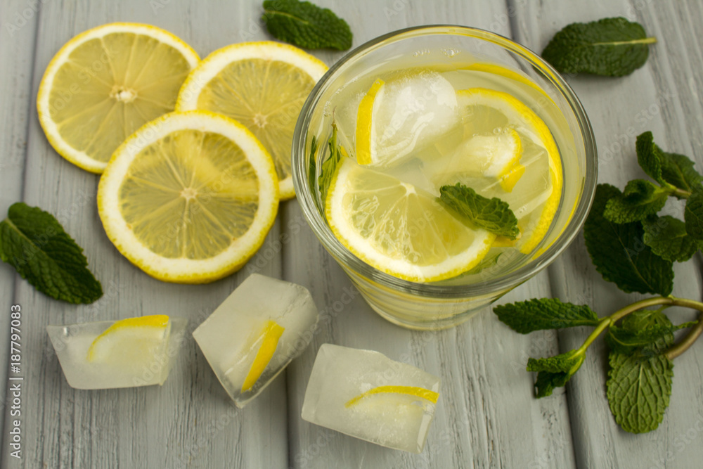 Homemade lemonade with lemon and mint on the grey wooden background.View from above. Homemade lemonade with lemon and mint on the grey wooden background.View from above.