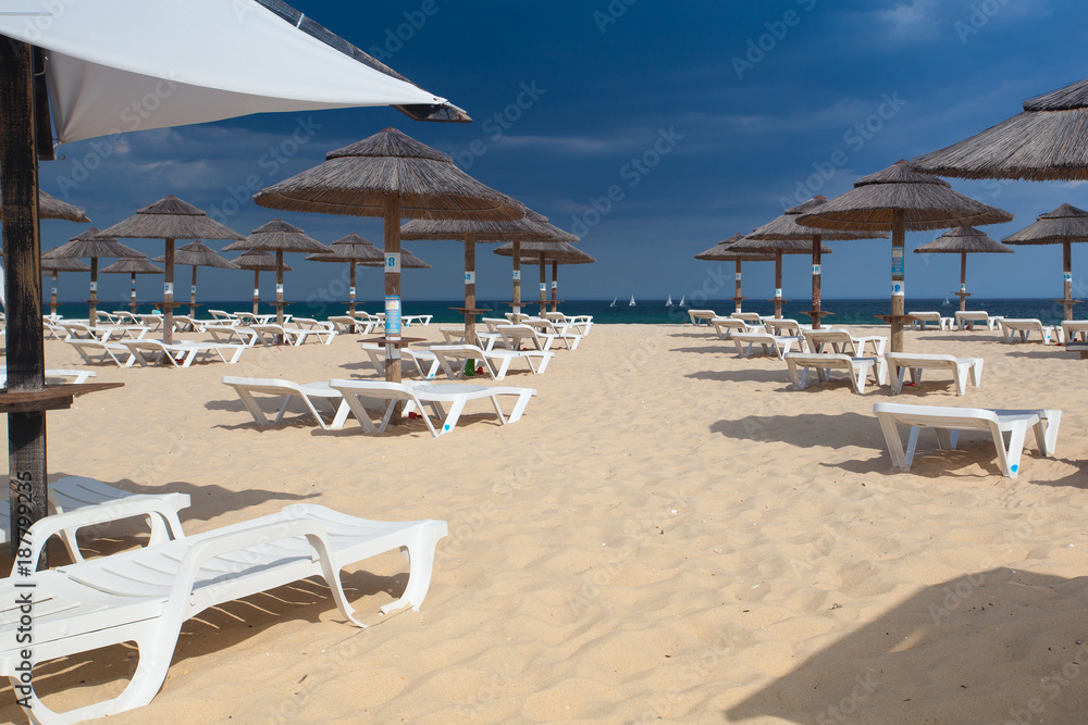 Rows of sun loungers and umbrellas on the beach.Tavira, Portugal