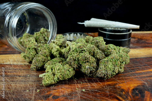 Quadro su tela One ounce marijuana with jar, joints and grinder against black background