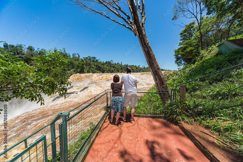 Man and woman on the Saltos del Monday a waterfall near the city Ciudad del Este in Paraguay