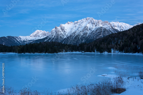 The frozen lake Lautersee near Mittenwald with snowy mountains © Asvolas