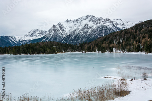 The frozen lake Lautersee near Mittenwald with snowy mountains © Asvolas
