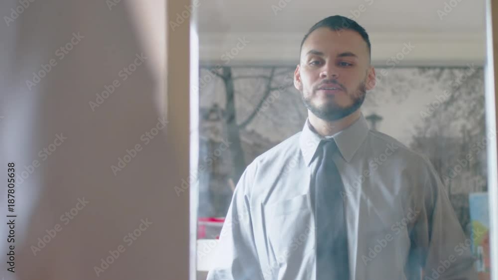 handsome hispanic millenial being funny in front of mirror handsome hispanic millenial being funny in front of mirror