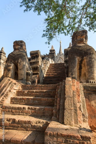 Two chinth (half-lion/half-dragon deities) guarding the stairway to the Mimalaung Kyaung in Bagan, Myanmar (Burma) on a sunny day.