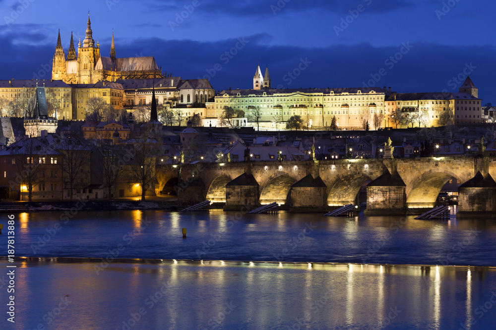 Obraz premium Evening colorful snowy Christmas Prague Lesser Town with gothic Castle and Charles Bridge, Czech republic