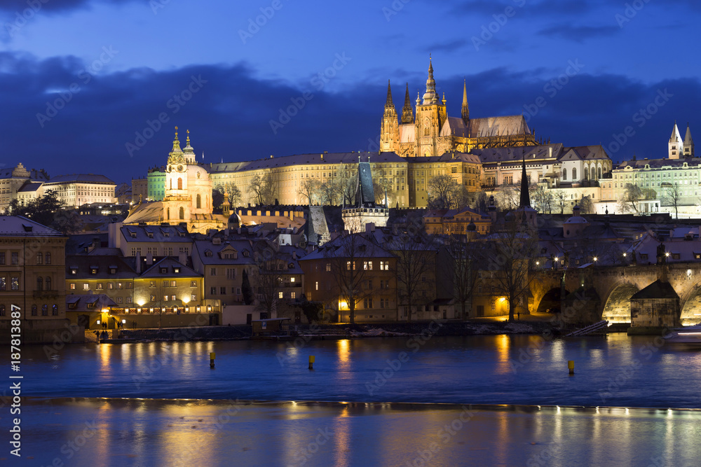 Evening colorful snowy Christmas Prague Lesser Town with gothic Castle and Charles Bridge, Czech republic