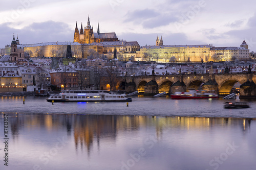 Evening colorful snowy Christmas Prague Lesser Town with gothic Castle and Charles Bridge, Czech republic