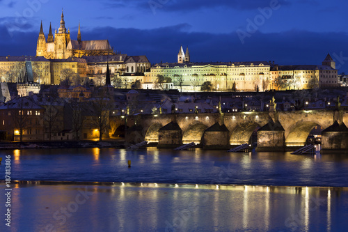 Evening colorful snowy Christmas Prague Lesser Town with gothic Castle and Charles Bridge, Czech republic