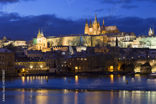 Evening colorful snowy Christmas Prague Lesser Town with gothic Castle and Charles Bridge, Czech republic