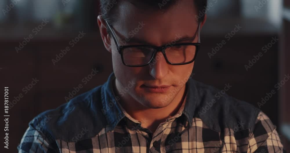 Attractive young man preparing for the work process, he puts on the glasses, drinks hot cup of tea. Working late at night, workaholic, cozy atmosphere. Productive day, modern lifestyle. Slow motion Attractive young man preparing for the work process, he puts on the glasses, drinks hot cup of tea. Working late at night, workaholic, cozy atmosphere. Productive day, modern lifestyle. Slow motion