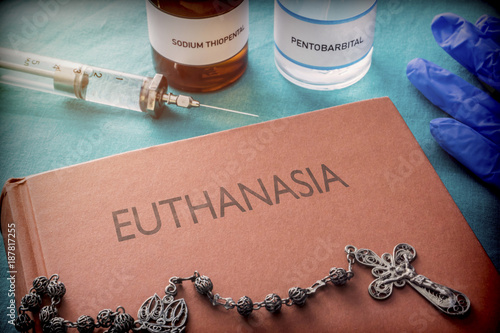 Vintage syringe and drugs used in lethal injection on a book of euthanasia, digital composition, conceptual image