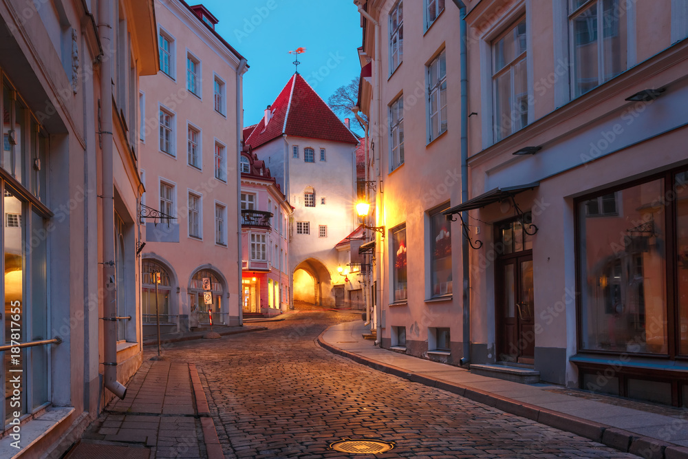 Beautiful illuminated medieval street in Old Town of Tallinn during evening blue hour, Estonia