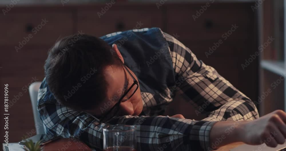 Tired young office worker has a nap on his workplace, wakes up, checks the computer and continues his rest. Workaholic, being exhausted, too tired. Slow motion, camera stabilizer shot, male portrait Tired young office worker has a nap on his workplace, wakes up, checks the computer and continues his rest. Workaholic, being exhausted, too tired. Slow motion, camera stabilizer shot, male portrait