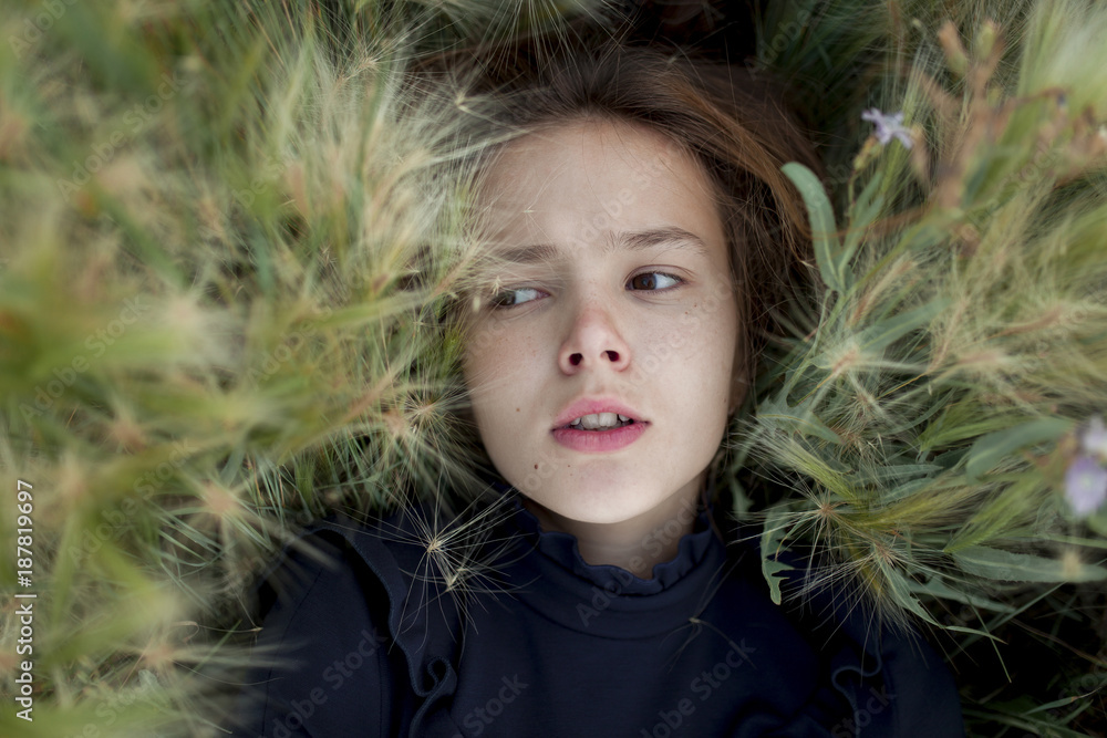Concerned Caucasian girl laying in field Concerned Caucasian girl laying in field